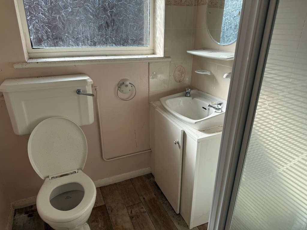 Lot: 128 - BUNGALOW WITH GARAGE AND GARDENS IN NEED OF MODERNISATION - Shower room with white suite and window to rear